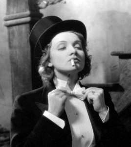 Marlene Dietrich anudándose la corbata de pajarita y con un cigarro en la boca