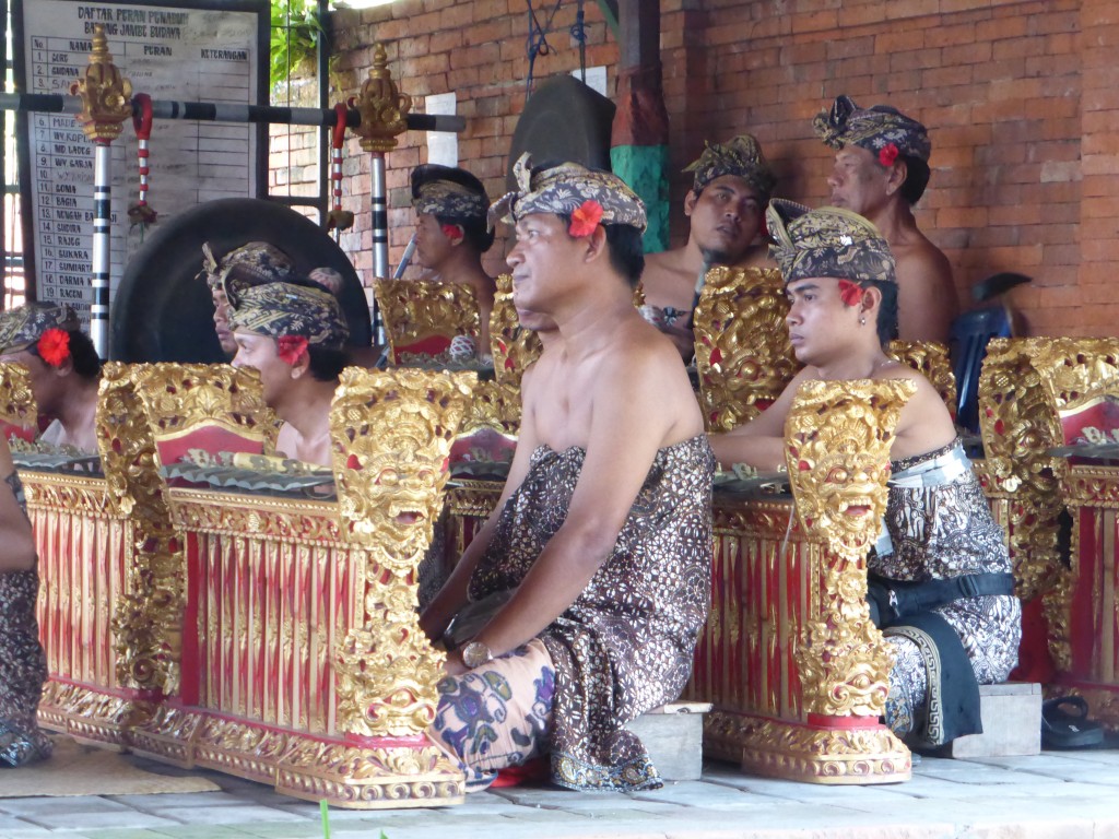 Músicos indonesios en representación local vestidos con trajes y tocados tradicionales de batik
